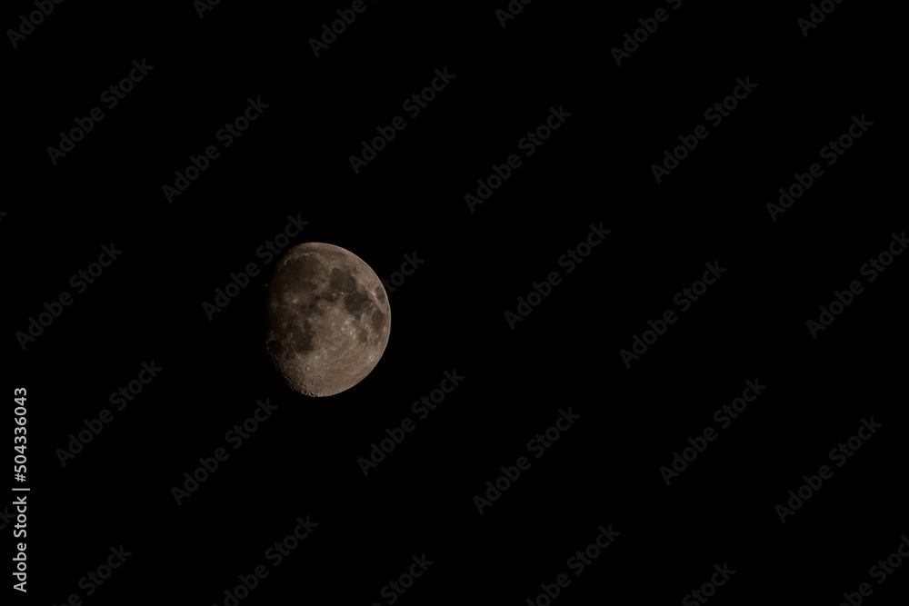 Close up of new moon with visible craters on its surface on black night sky background with copy space Close up of new moon with visible craters on its surface on black night sky background with copy space