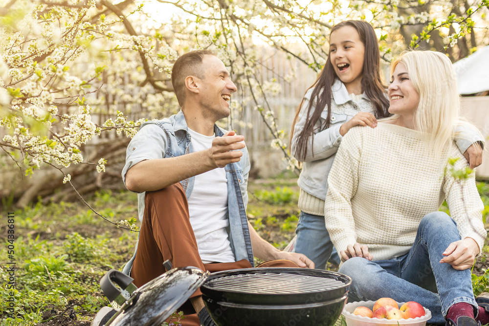 Happy family having barbecue with modern grill outdoors Happy family having barbecue with modern grill outdoors