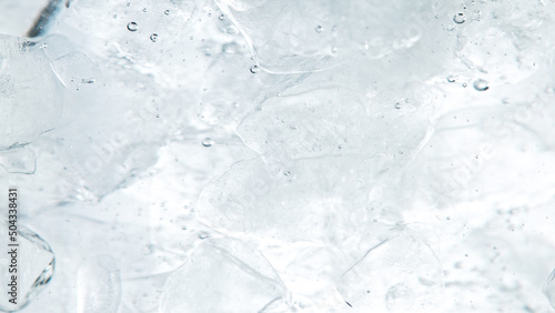 Close up of ice cubes underwater, blue background.
