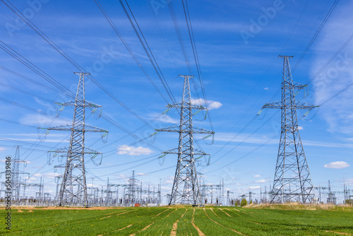 High voltage electricity towers, transmission power lines, cables on transformers, and distribution substation