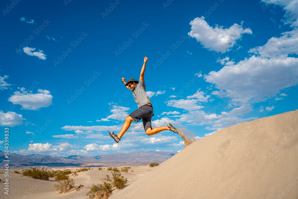 A young man jumping in desert on a summer afternoon in Death Valley, California A young man jumping in desert on a summer afternoon in Death Valley, California