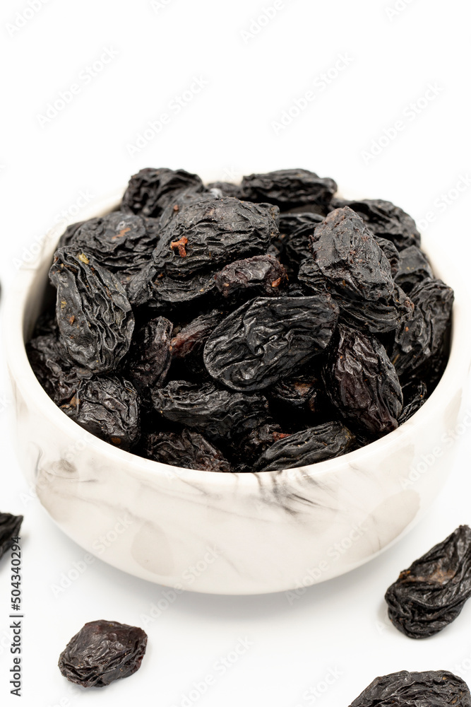 Black dried raisins on a white background. healthy and fresh.nuts. Close-up. Black dried raisins on a white background. healthy and fresh.nuts. Close-up.