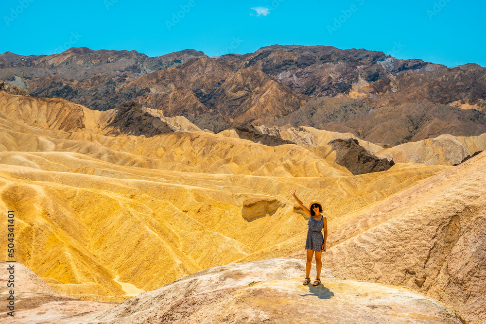 A young woman in dress enjoying the view of the viewpoint of Zabriskie Point, California. United States
