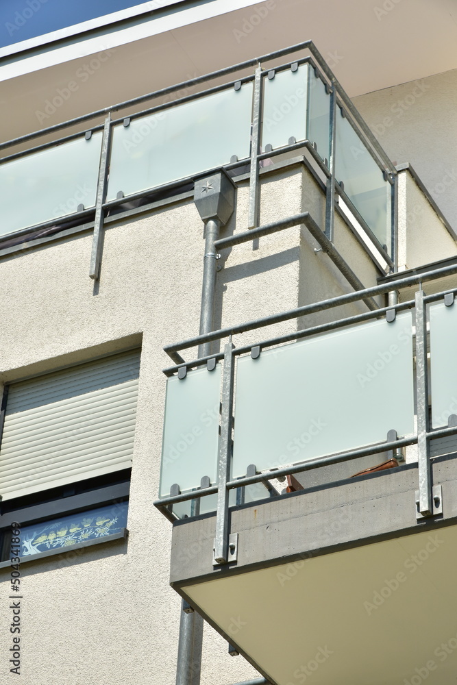 Balkon mit Metallgeländer als Sturzsicherung und MattglasPlatten als