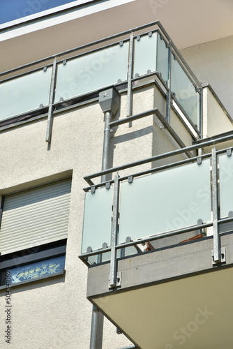 Balkon mit Metallgeländer als Sturzsicherung und Mattglas-Platten als Sichtschutz