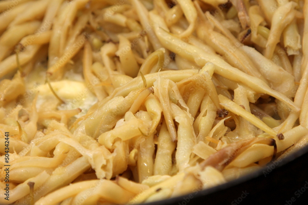 Fresh butter beans are baked in a metal pan. Close up of yellow string beans in a pan, Fried butter beans Fresh butter beans are baked in a metal pan. Close up of yellow string beans in a pan, Fried butter beans