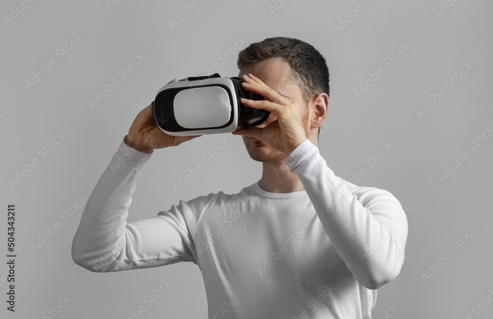 Modern young man experiencing virtual reality glasses in studio Modern young man experiencing virtual reality glasses in studio
