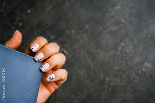Woman's hands with a colorful patterns on the nails. 2022-2023 colors trend. Top view. A place for text. 