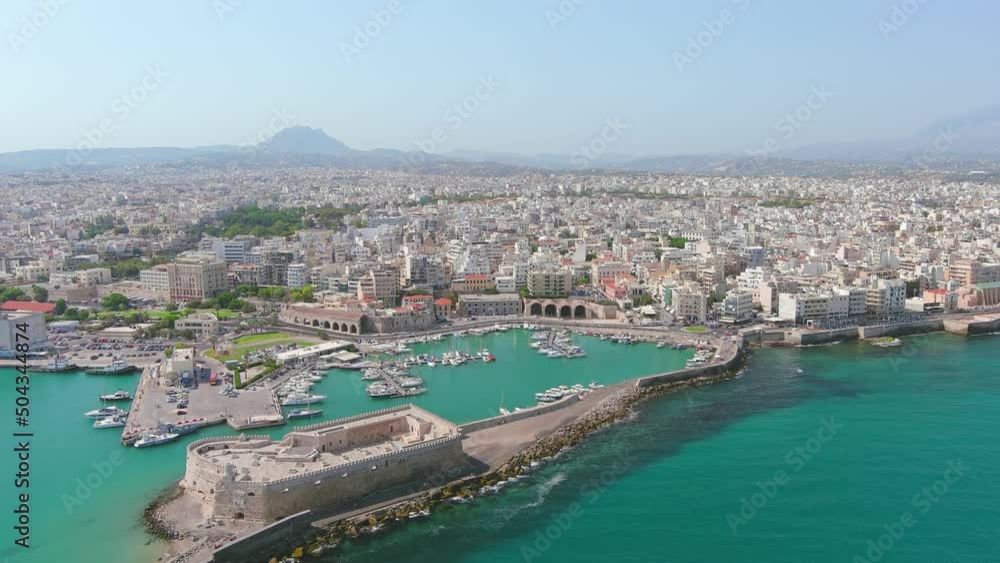Heraklion, Greece: Aerial view of capital city of Greek island of Crete, Rocca a Mare Fortress, clear waters of Mediterranean Sea, yachts and ships in city marina - landscape panorama of Europe from a Heraklion, Greece: Aerial view of capital city of Greek island of Crete, Rocca a Mare Fortress, clear waters of Mediterranean Sea, yachts and ships in city marina - landscape panorama of Europe from a