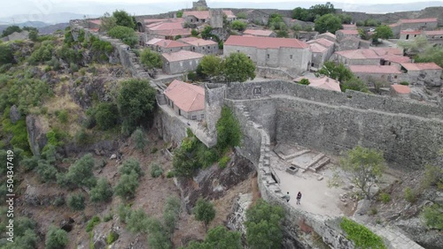 Ramparts surrounding historical village of Sortelha, Portugal; aerial pan photo