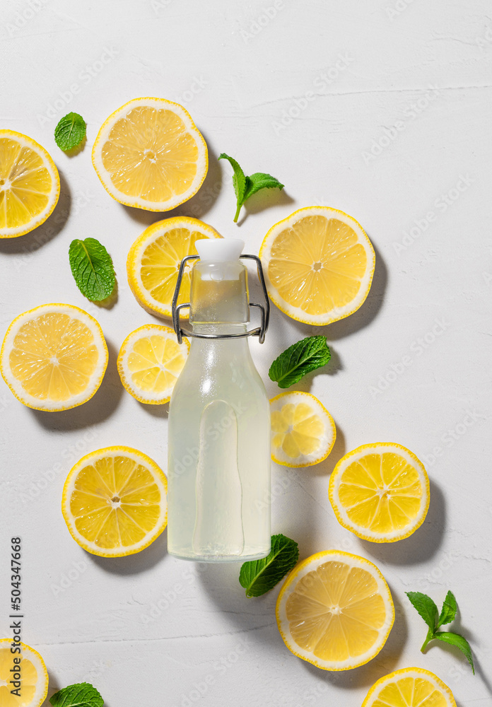 Fresh lemon mint detox drink in glass bottle on white background with ingredients. Summer background. healthy nutrition diet concept. vertical image Fresh lemon mint detox drink in glass bottle on white background with ingredients. Summer background. healthy nutrition diet concept. vertical image