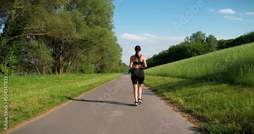 Young Woman Running on a Street in a beautiful nature landscape