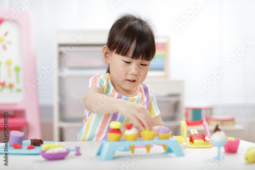 young girl making  food using dough tools  for homeschooling
