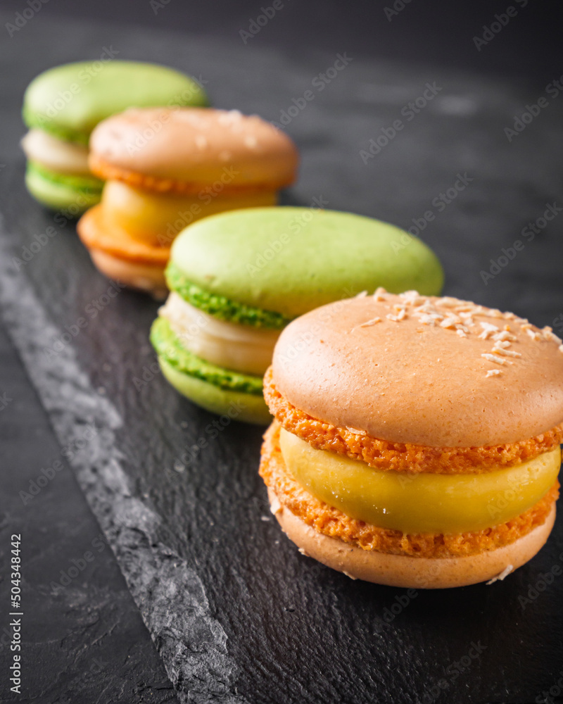 colored macaroons on a dark stone background