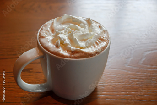 Quadro em tela Closeup hot mocha fresh coffee in a white cup with whipping cream on wooden table background