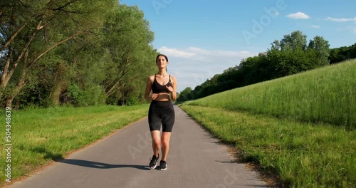 Establishing shot of a woman running on a Track in a natural landscape