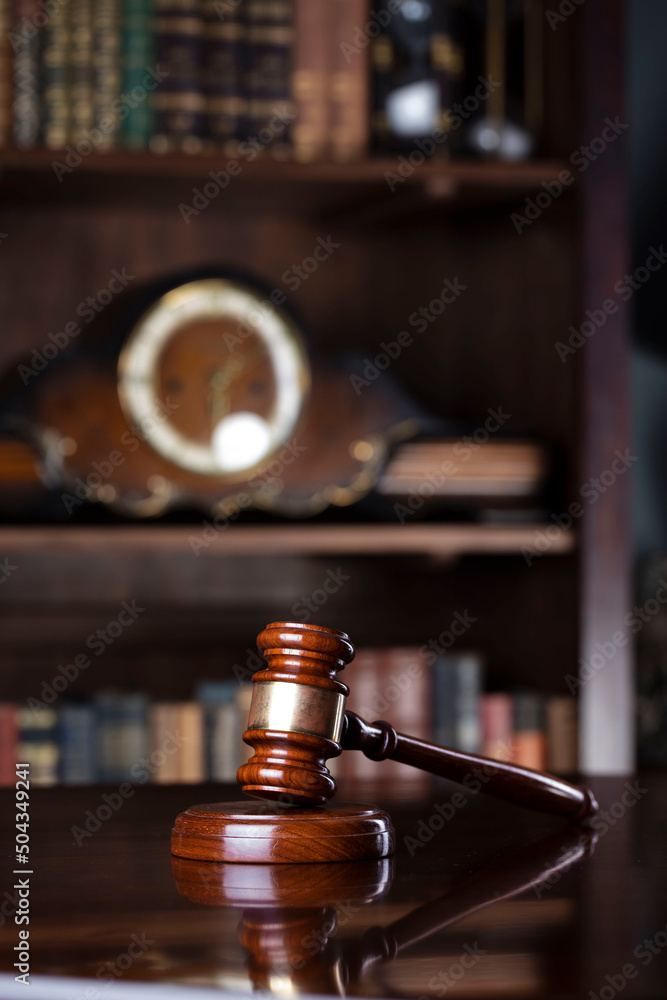 Judge office. Gavel on the judge desk. Book shelf in the background.
