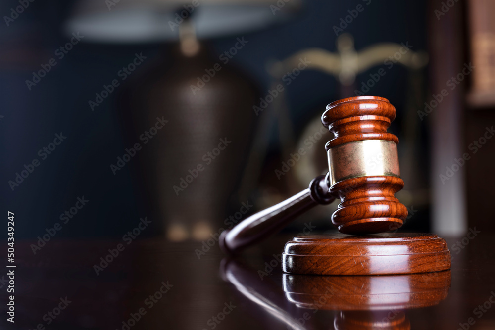 Judge office. Gavel on the judge desk. Book shelf in the background. Judge office. Gavel on the judge desk. Book shelf in the background.