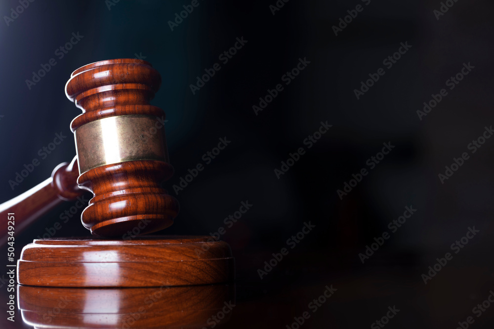 Judge office. Gavel on the judge desk. Book shelf in the background. Judge office. Gavel on the judge desk. Book shelf in the background.