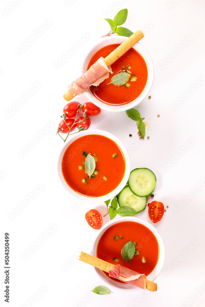 Fototapeta premium cold gazpacho with tomato, cucumber, bell pepper and basil on white background