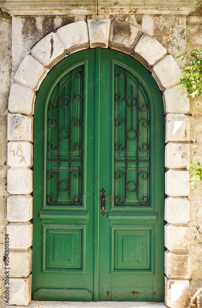 Green old textured door in a stone wall, Rovinj, Croatia, Europe 