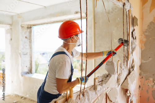 Repairer in boilersuit holding tools. Apartment repair and renovation concept. photo