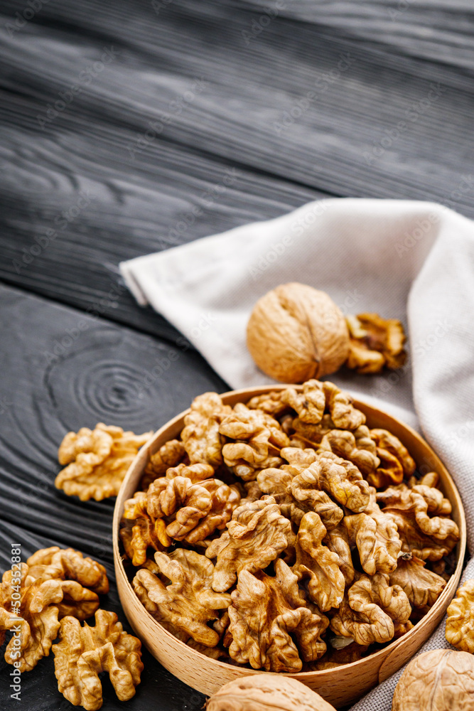Obraz premium dried walnuts on a black rustic wooden background