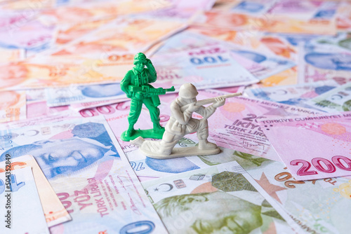 Εκτύπωση καμβά Two toy soldiers on Turkish Lira, spending money for war, mercenary concept, con