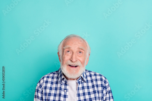 Portrait of cute dreamy granddad looking up blank space see promotional advert isolated on turquoise color background
