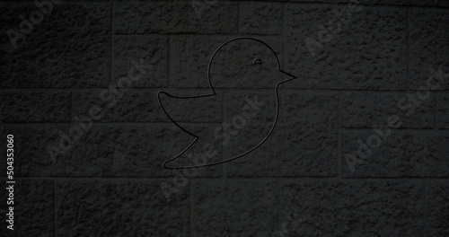 Image of glowing neon bird icon on brick wall