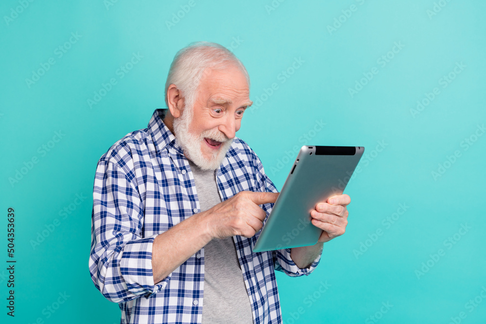 Photo of cheerful pensioner see huge bargains on black friday surfing online store isolated on teal color background Photo of cheerful pensioner see huge bargains on black friday surfing online store isolated on teal color background