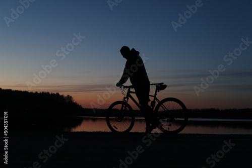 Silhouette of a bicyclist on the beach at sunset