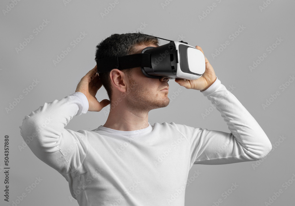 Modern young man experiencing virtual reality glasses in studio Modern young man experiencing virtual reality glasses in studio