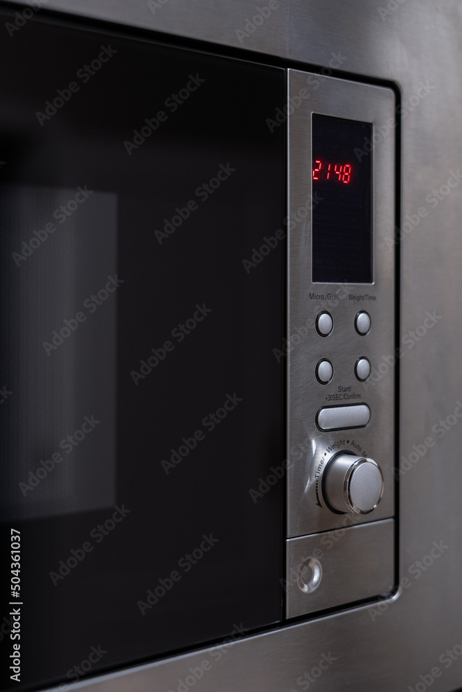 Modern grey microwave oven with timer in kitchen Modern grey microwave oven with timer in kitchen
