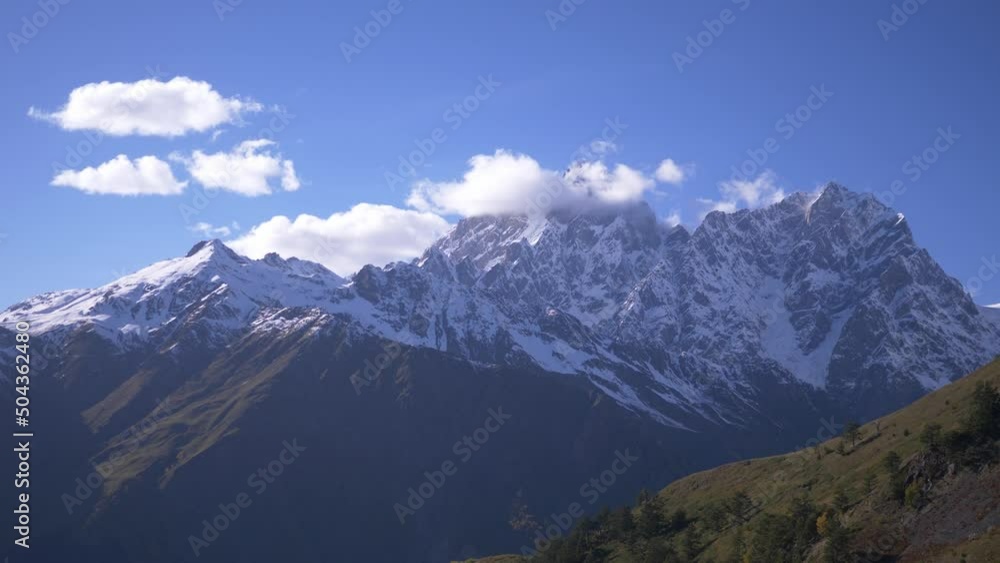 snow covered mountain with clouds in the foreground, close-up snow covered mountain with clouds in the foreground, close-up