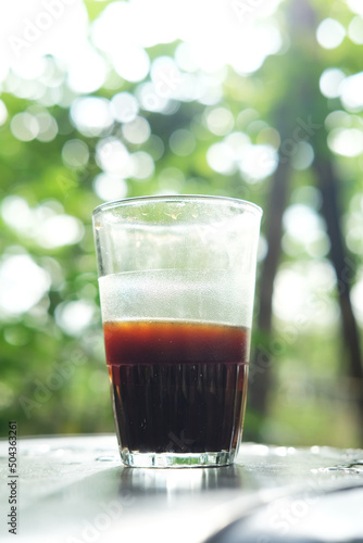 Black coffee in a glass on a blurred background in the morning