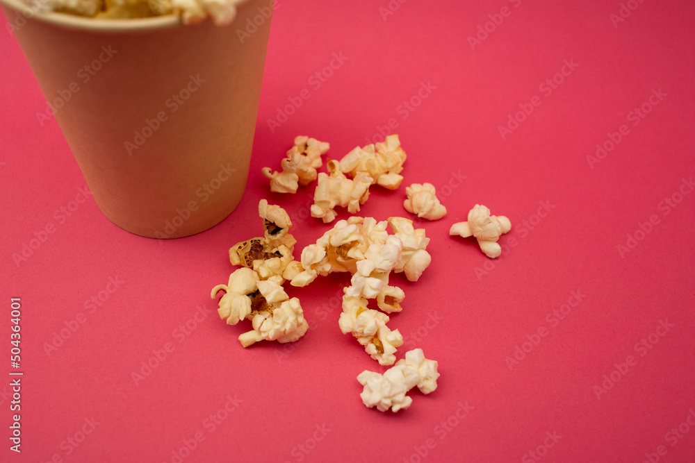Popcorn in a cup on a bright pink background Popcorn in a cup on a bright pink background