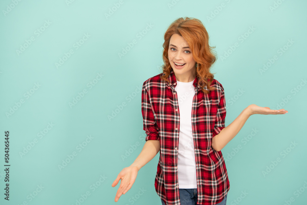 surprised redhead woman in checkered shirt on blue background with copy space surprised redhead woman in checkered shirt on blue background with copy space