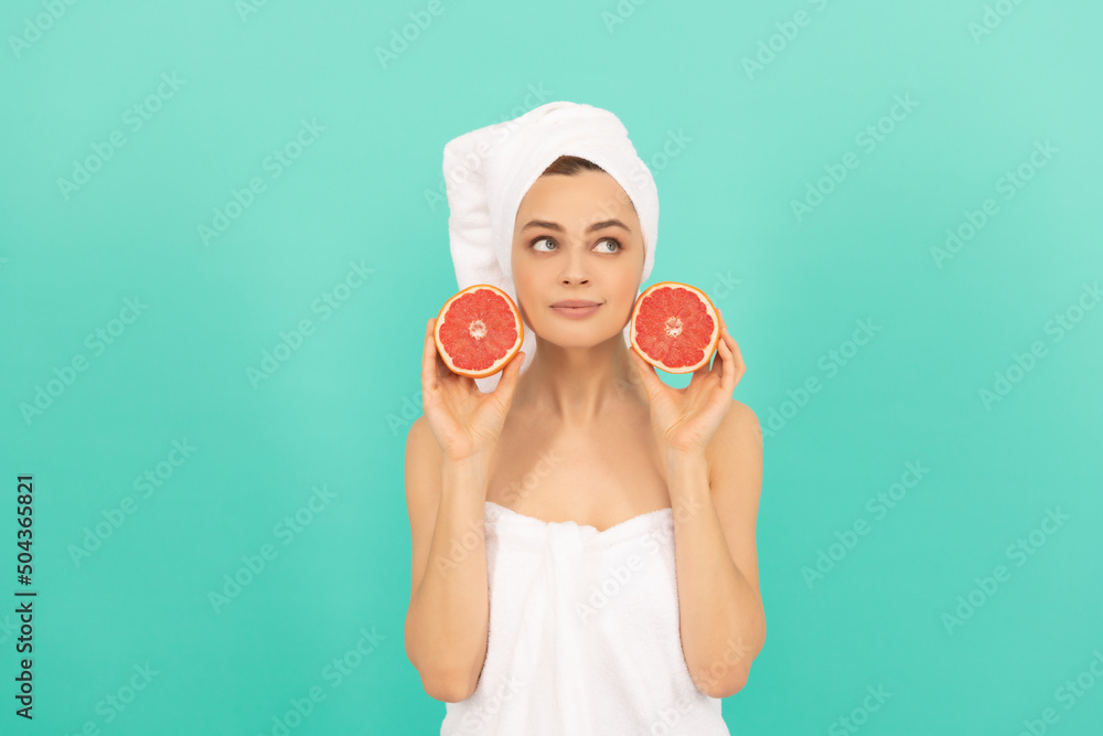dreamy young girl in towel after shower with grapefruit on blue background dreamy young girl in towel after shower with grapefruit on blue background