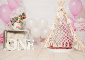 pink and white decoration for a 1st birthday cake smash studio photo shoot with balloons, paper decor, cake and topper. High quality photo