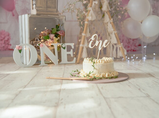 pink and white decoration for a 1st birthday cake smash studio photo shoot with balloons, paper decor, cake and topper. High quality photo