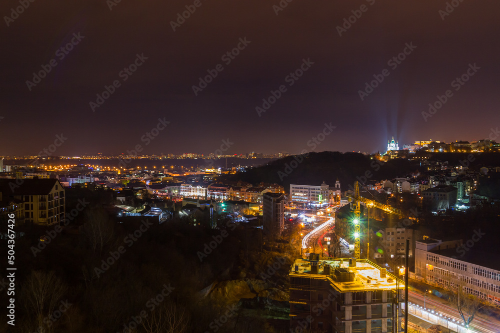 Fototapeta premium Ukraine, Kyiv – November 26, 2016: Aerial panoramic view on central and historical part of Kyiv city, residential area in the evening. St Andrew's Church, Podil area.
