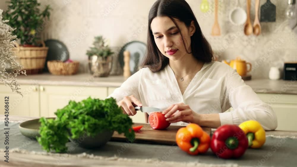 Portrait of attractive cheerful woman cooking vegetables on dometic kitchen in slow motion. Portrait of attractive cheerful woman cooking vegetables on dometic kitchen in slow motion.