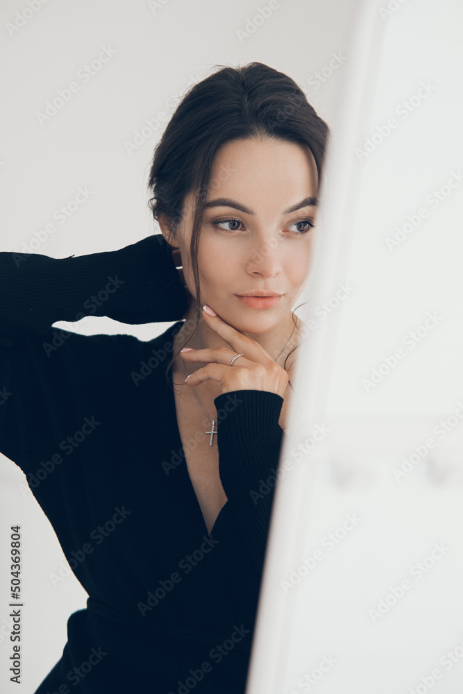 Portrait of young pensive woman posing near white curtains. Portrait of young pensive woman posing near white curtains.