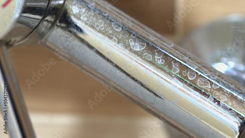Close-up of a faucet in the kitchen with a lime coating