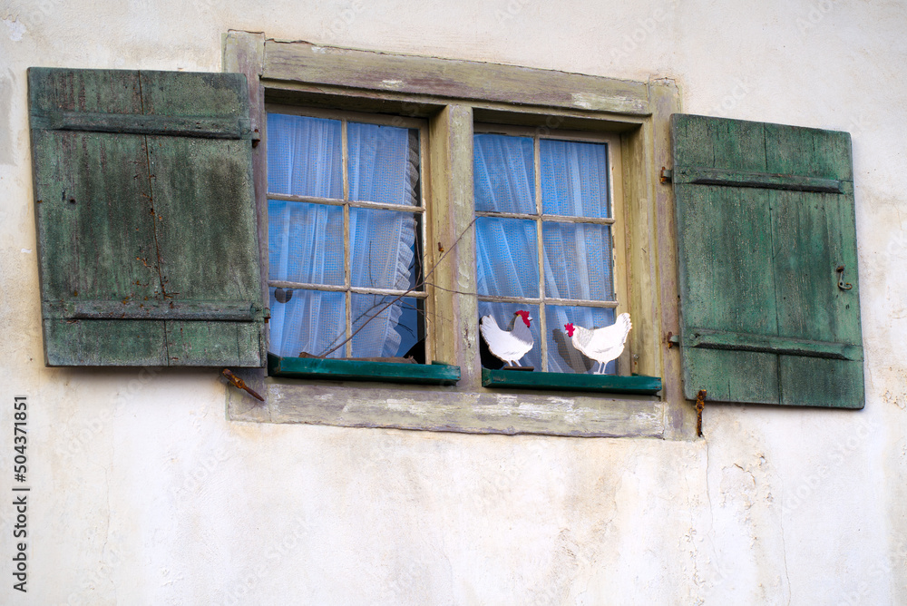 Easter decoration with two white wooden chicken on window ledge of medieval house at Zürich Schwamendingen. Photo taken April 7th, 2022, Zurich, Switzerland.