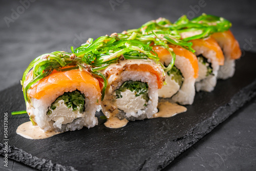 delicious sushi rolls on a black stone background