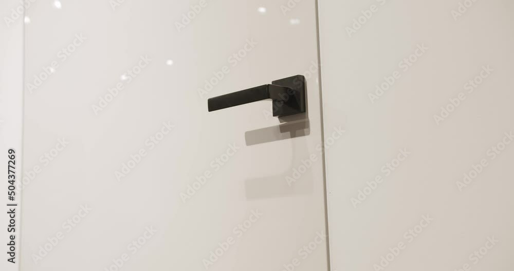 Close Up The minimalist white door in a modern home. Modern Apartment with white modern door and black minimalist handle. Lifestyle and Elegant room. Modern Showroom. Close Up The minimalist white door in a modern home. Modern Apartment with white modern door and black minimalist handle. Lifestyle and Elegant room. Modern Showroom.