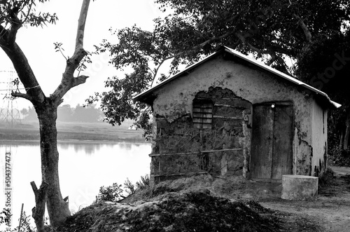 Canvas Print A dilapidated and abandoned hut by the river outside a village