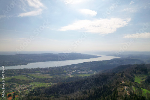 Panoramic view from local mountain Uetliberg with Lake Zürich and Swiss Alps in the background on a blue cloudy spring day. Photo taken April 14th, 2022, Zurich, Switzerland.